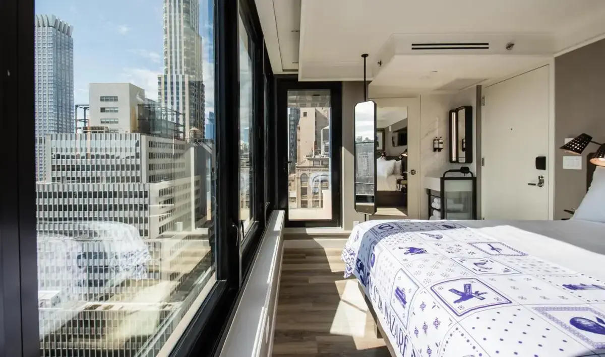 a bedroom with a bed and a view of the city at Pestana Park Avenue in New York