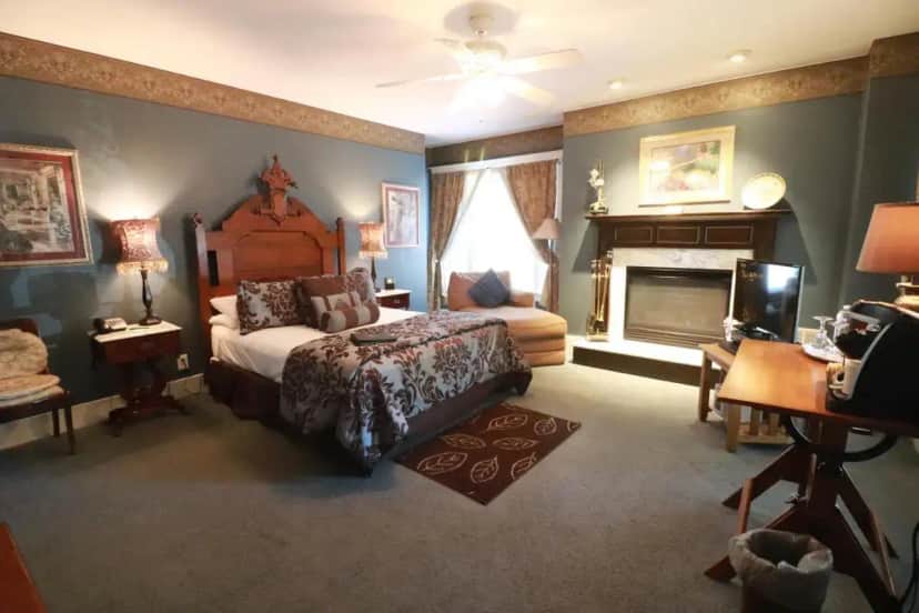 a bedroom with a large bed and a fireplace at Inn at 835 Boutique Hotel in Springfield