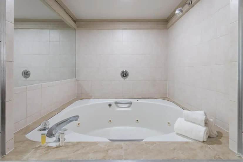 a white bath tub in a bathroom with a sink at Inn at Atlantic City Hotel & Banquet in Absecon