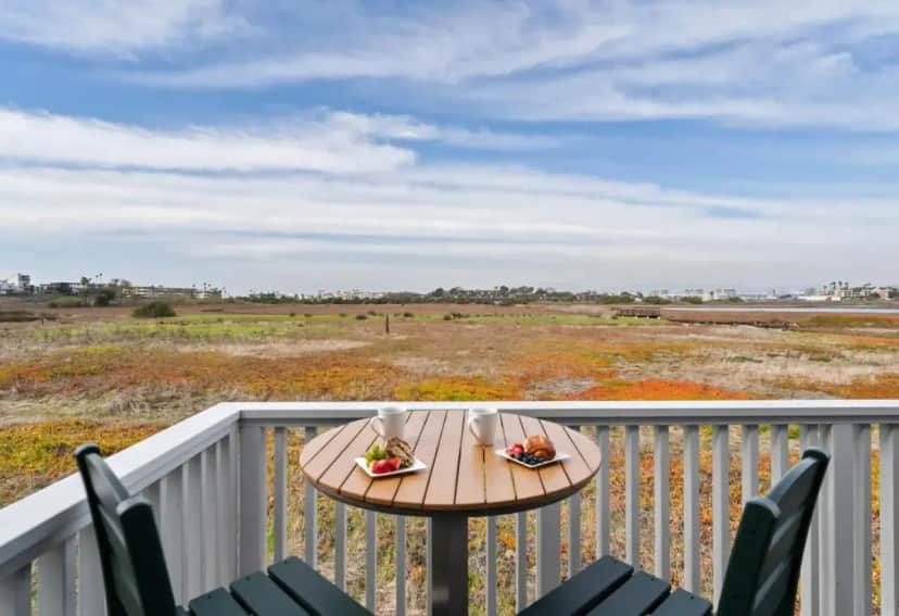 a table on a balcony with a view of a field at Inn at Playa del Rey in Los Angeles