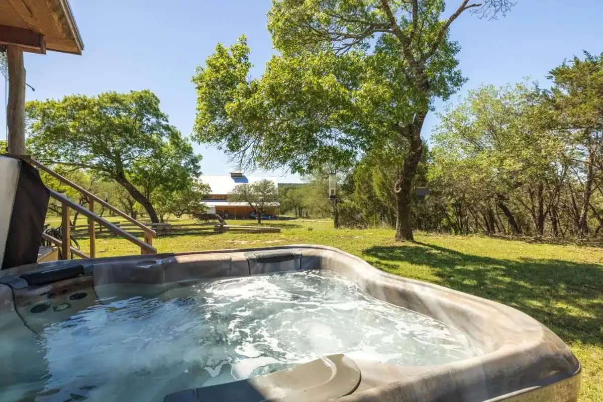 a hot tub in a yard with trees at Inn at Sunset Mill Ranch in Wimberley