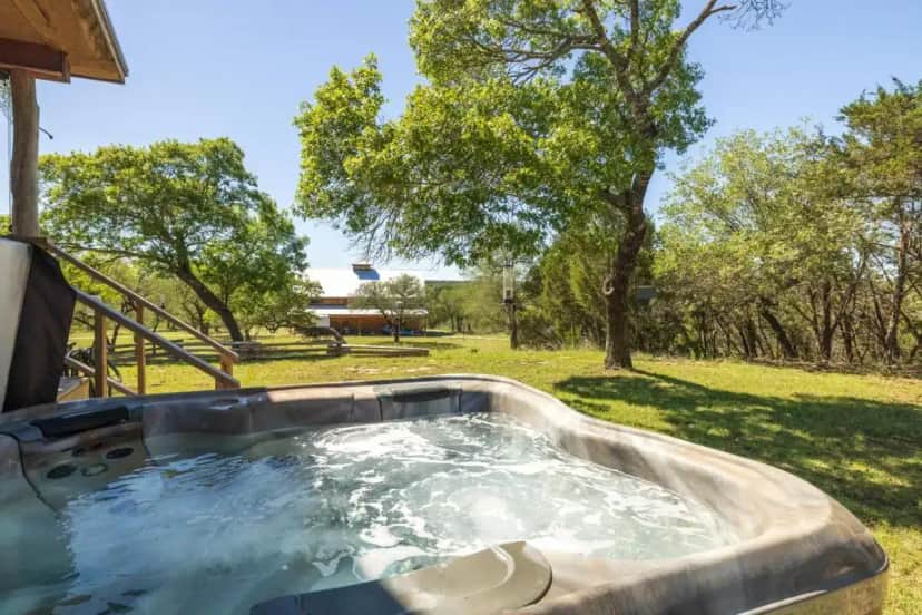 a hot tub in a yard with trees at Inn at Sunset Mill Ranch in Wimberley