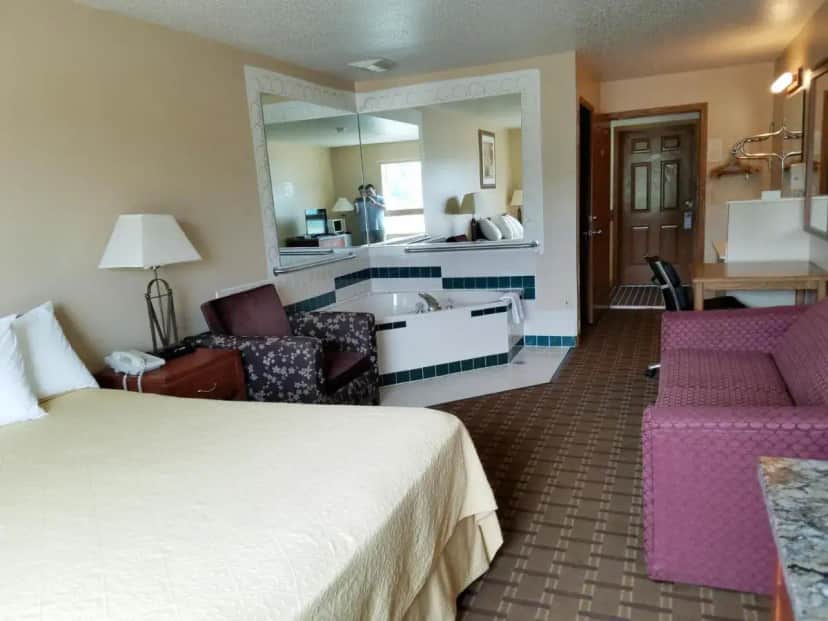 a hotel room with a bed and a bathroom at Inn of the Pines in Adams