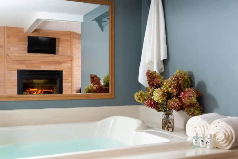 a bathroom with a white tub and a fireplace at Justin Trails Resort in Sparta