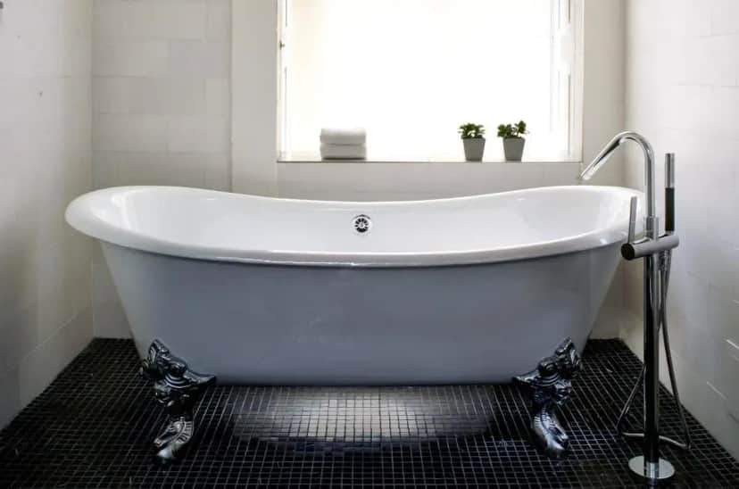 a white bath tub in a bathroom with a window at Kimpton Hotel Monaco Washington DC by IHG in Washington, D.C.