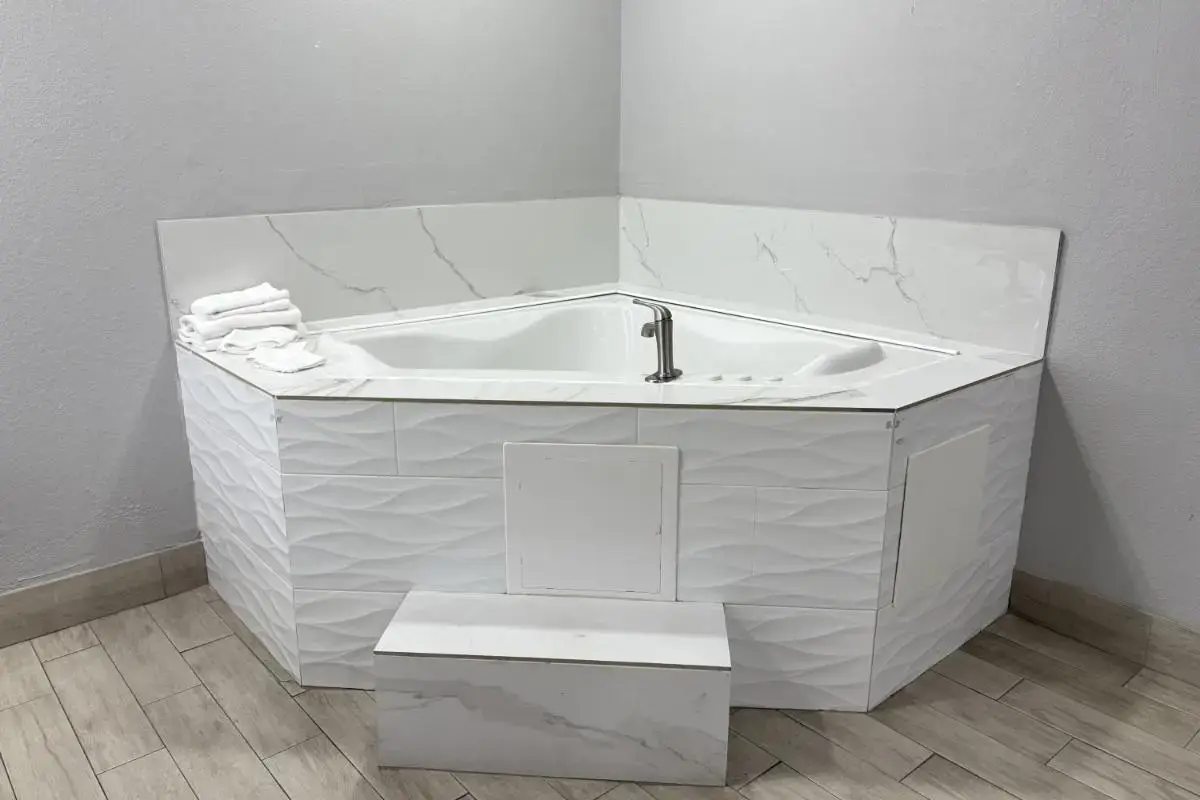 a white bath tub with a sink in a bathroom at Kiwi Inn Capital O Houston - Hwy 249 in Houston