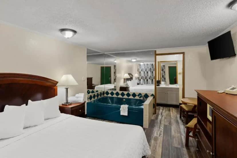 a hotel room with a bed and a tub in it at Knights Inn Ashland in Ashland