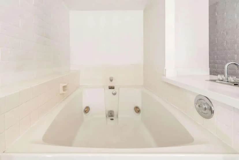a white bath tub in a bathroom with a sink at Knights Inn Dayton by Miller Lane in Dayton