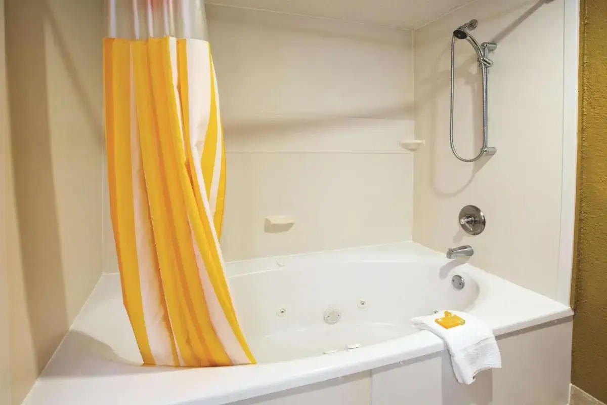 a bathroom with a tub and a shower with a shower curtain at La Quinta by Wyndham Hot Springs in Hot Springs