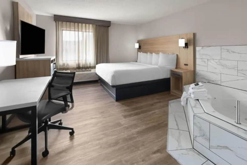 a hotel room with a bed and a desk at La Quinta by Wyndham Mansfield OH in Mansfield