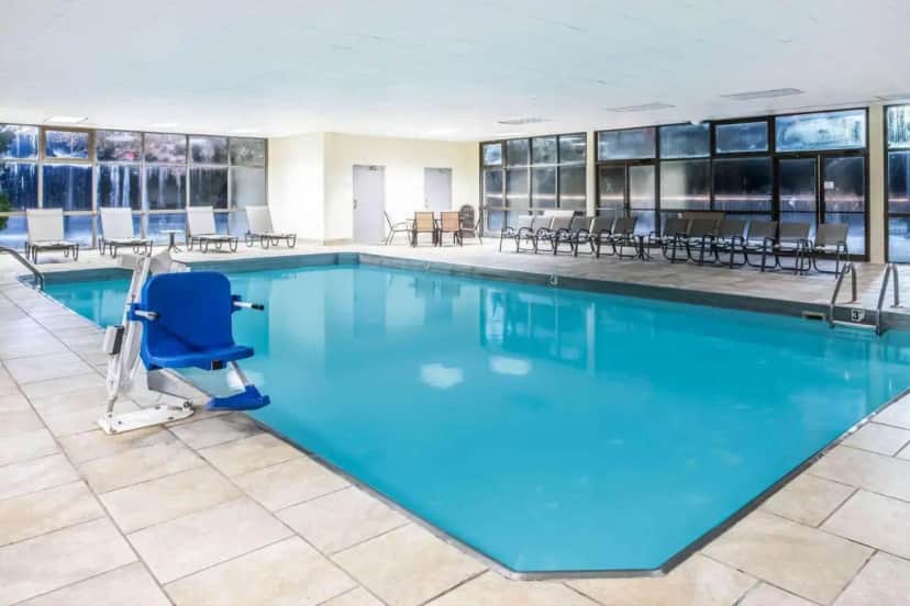 a large swimming pool with a chair in a building at La Quinta Inn by Wyndham Davenport & Conference Center in Davenport