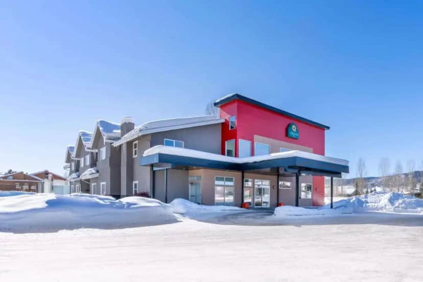 a red building with snow in front of it at La Quinta Inn by Wyndham Steamboat Springs in Steamboat Springs