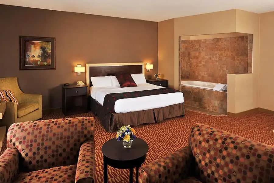 a hotel room with a bed and a couch at Lakeside Hotel Casino, a Travelodge by Wyndham in Osceola