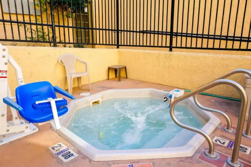 a jacuzzi bathtub with a chair at Lamplighter Inn & Suites in San Luis Obispo