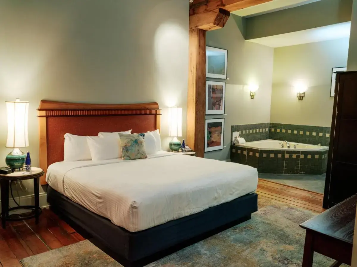 a bedroom with a bed and a tub in it at Lancaster Arts Hotel in Lancaster