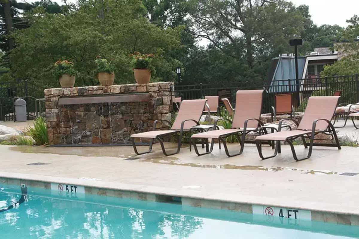 a group of chairs and a fireplace next to a swimming pool at Lantern Lodge in Asheville
