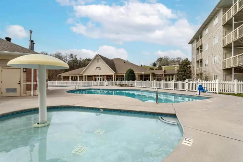 a swimming pool in a courtyard with a building at LeConte Hotel & Convention Center, an Ascend Collection Hotel in Pigeon Forge