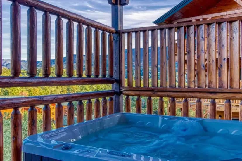 a hot tub on a deck with a wooden fence at Living The Dream, Mtn Views, Theater Room, 560 FREE tickets each paid day!!! in Gatlinburg