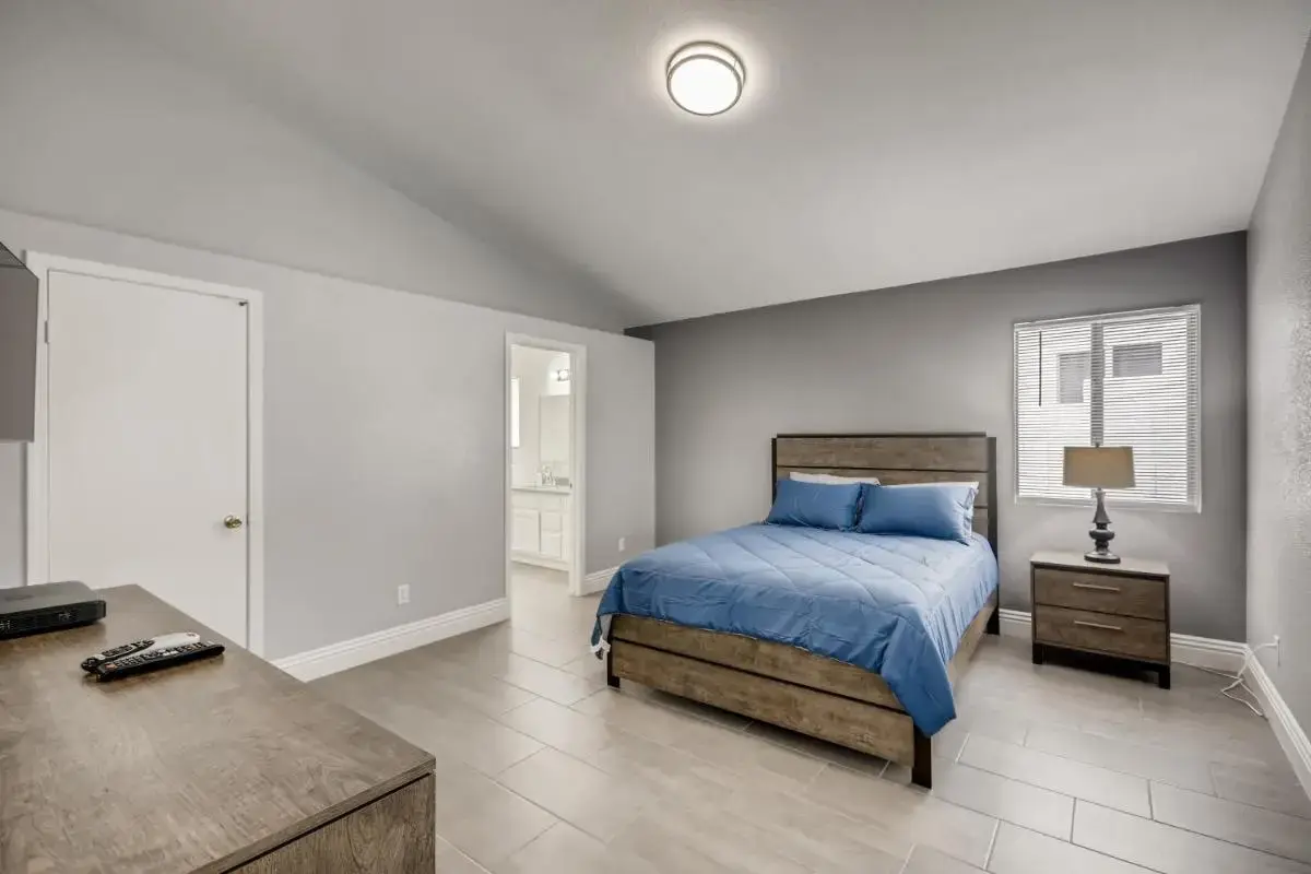 a bedroom with a bed and a table in it at Luxurious House With A Pool, Spa, and Patio, Sleeps 6 Comfortably in Las Vegas