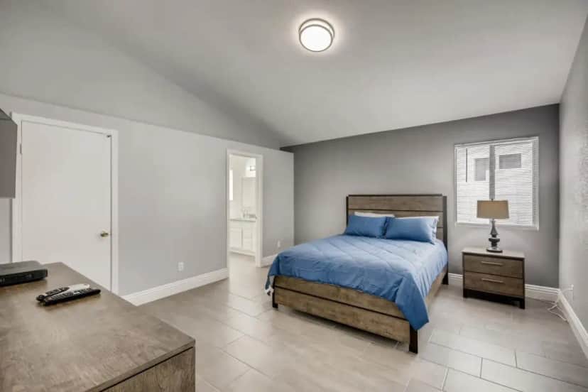 a bedroom with a bed and a table in it at Luxurious House With A Pool, Spa, and Patio, Sleeps 6 Comfortably in Las Vegas