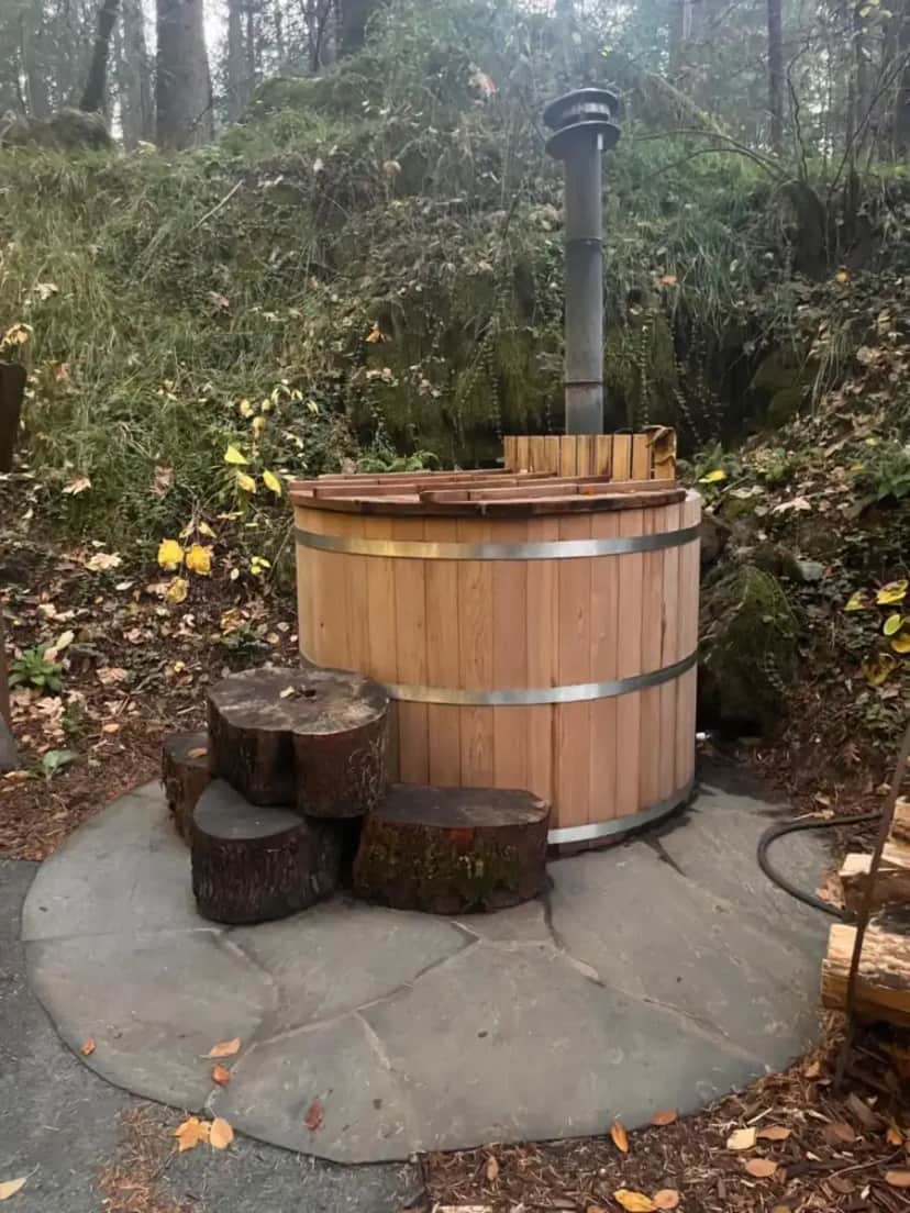 a wooden hot tub with logs and a pile thereof at Magical Yurt in the woods - 2 miles from town in Nevada City