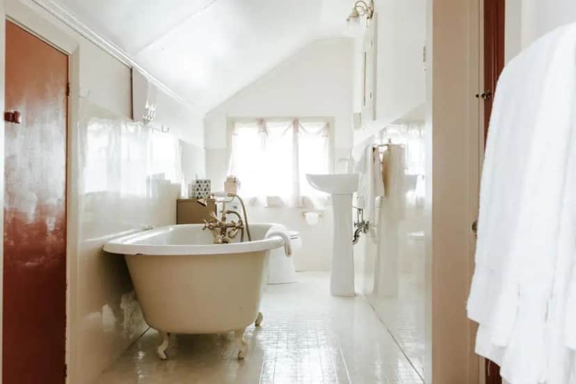 a white bathroom with a tub and a sink at Maison Mouton Bed & Breakfast in Lafayette