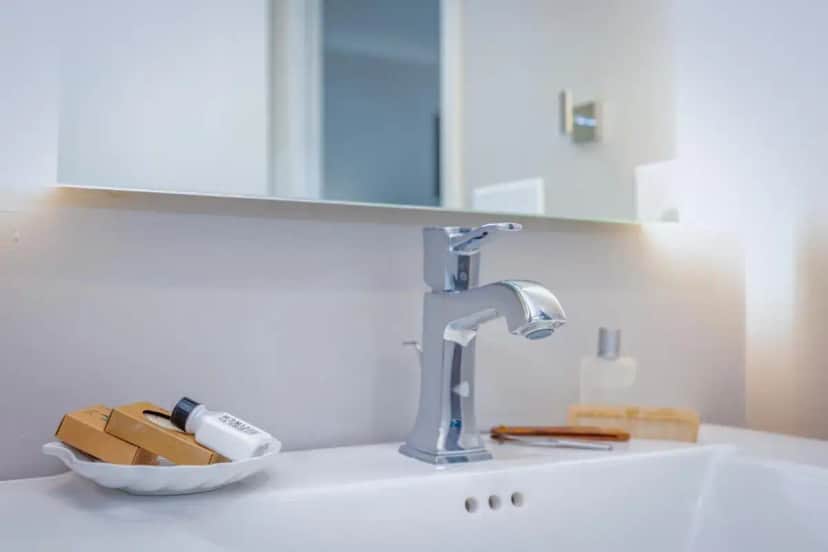 a bathroom sink with a faucet and a bowl of soap at Marina Beach Hotel in Santa Barbara