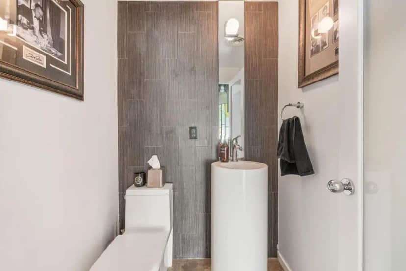 a bathroom with a toilet and a sink and a mirror at Mesquite Retreat in Palm Springs