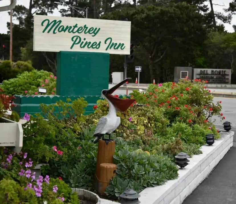 a statue of a pelican in a flower garden at Monterey Pines Inn in Monterey