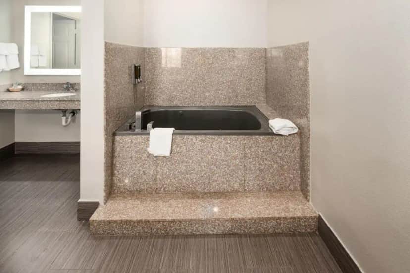 a bathroom with a bath tub and a sink at Moonlight Suites - Houston/George Bush Int'l Airport in Houston
