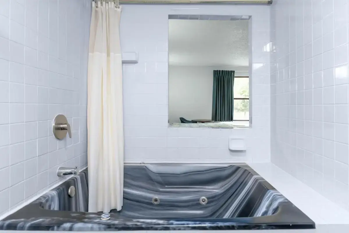 a bathroom with a tub with a shower curtain at Motel 6 - Franklin, OH in Franklin