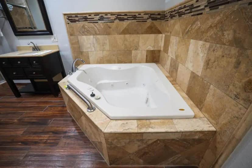 a large bath tub in a bathroom with a sink at Motel 6, Tustin, Orange County-CA in Tustin
