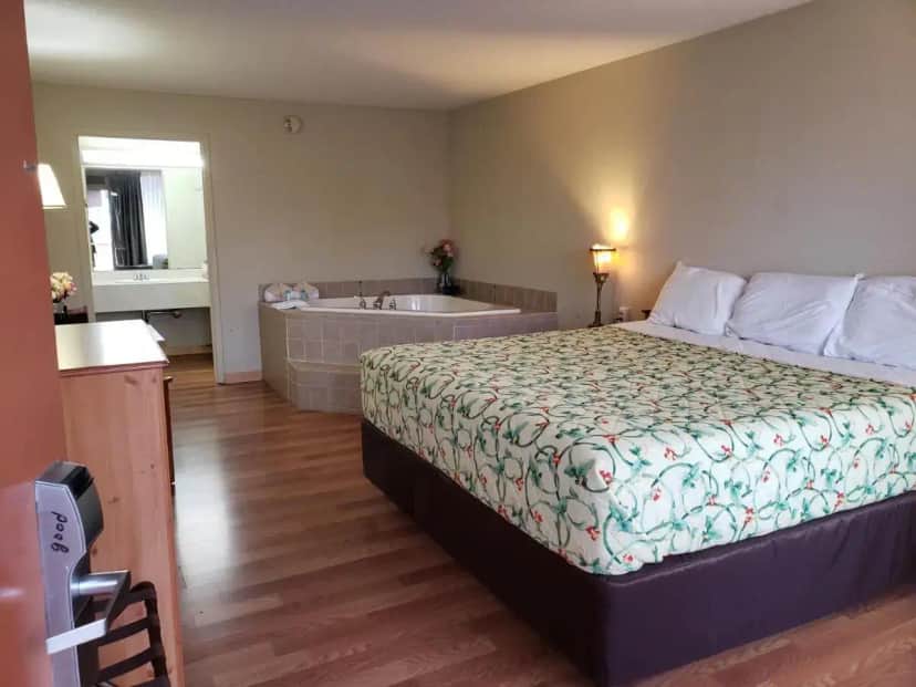 a hotel room with a bed and a bath tub at Mountain Home Inn in Mountain Home
