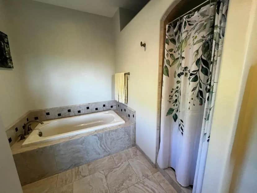 a bath tub in a bathroom with a shower at Natures Oasis Sanctuary B&B Organic Gardens in Cornville