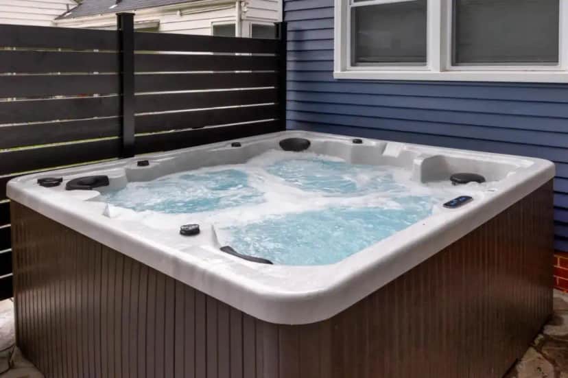 a large bath tub with blue water in it at Near Drake/Downtown packed w/Amenities - Hot Tub - Movie Theater in Des Moines
