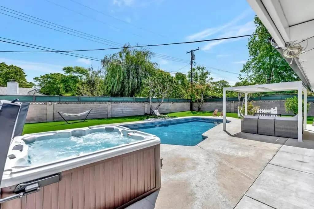 a hot tub in the backyard of a house at New cheerful villa, Pool, Spa, Mini Golf, Game room, Fire pit next to Disneyland in Anaheim
