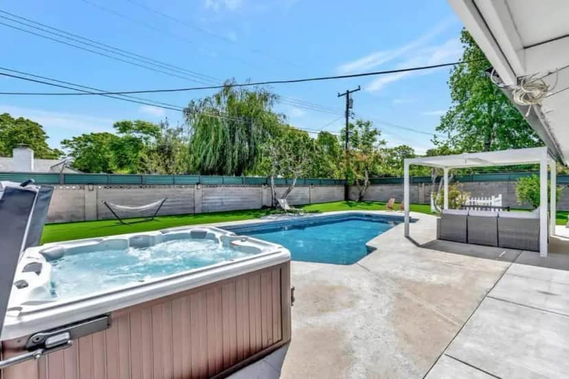a hot tub in the backyard of a house at New cheerful villa, Pool, Spa, Mini Golf, Game room, Fire pit next to Disneyland in Anaheim