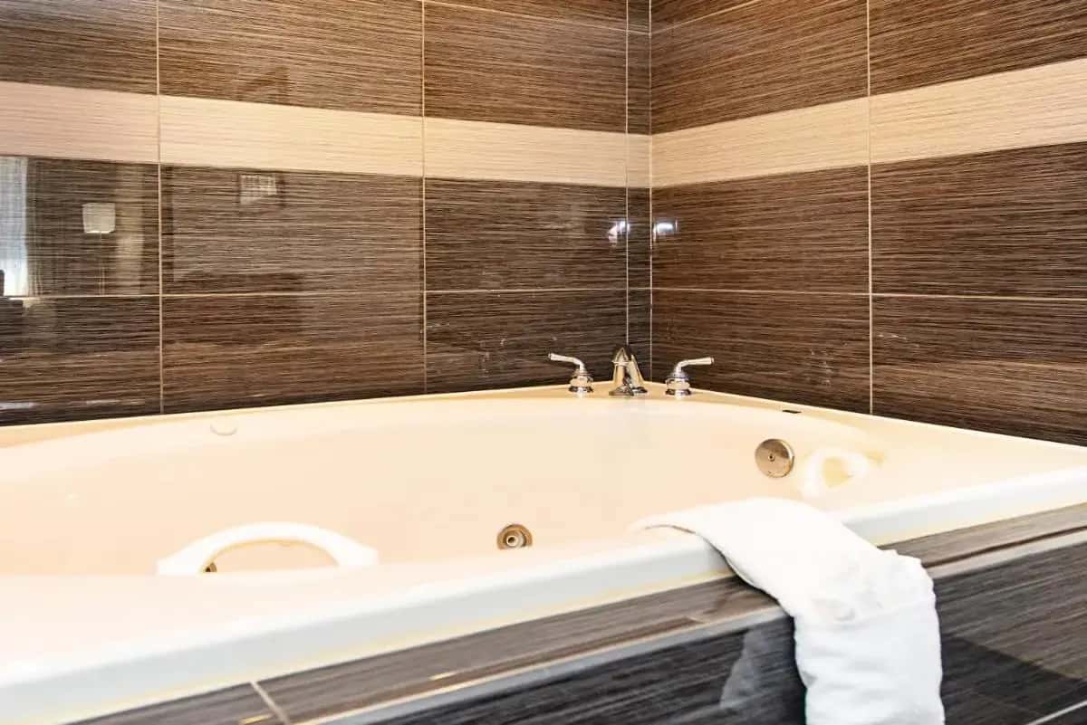 a bathroom with a bath tub with a towel at New Hope Inn & Suites in New Hope