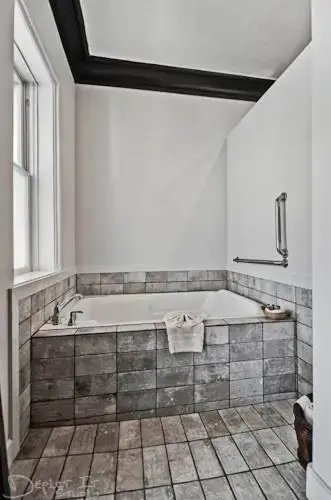 a bath tub in a bathroom with a window at New Orleans Hotel Eureka Springs in Eureka Springs