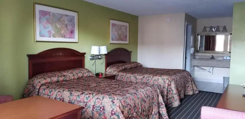 a hotel room with two beds and a table at Newport News Inn in Newport News