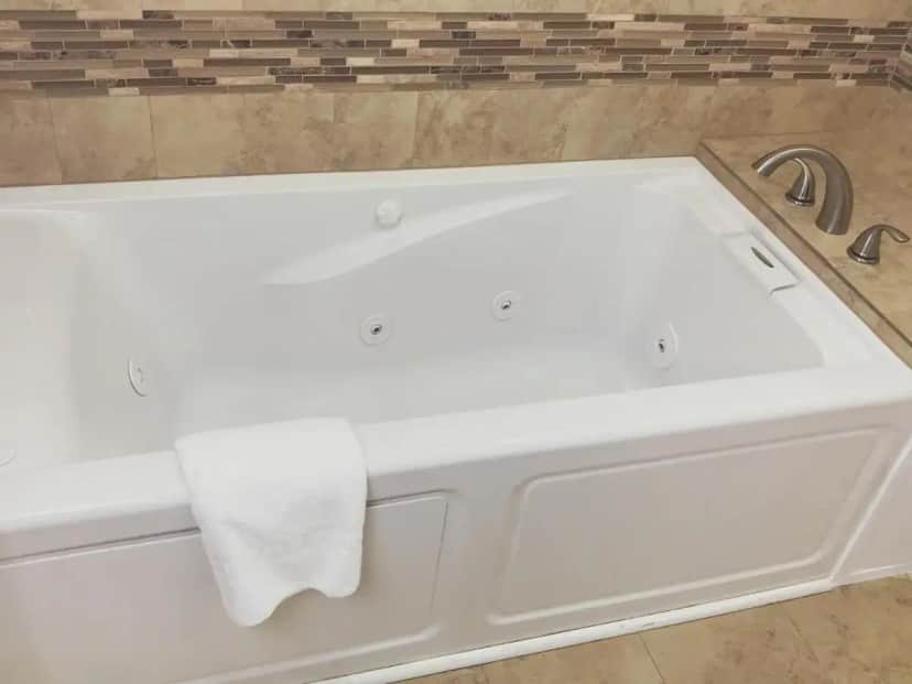 a white bath tub with a white towel on it at Nite Inn at Universal City - Walking Distance to Universal Studios Hollywood in Los Angeles