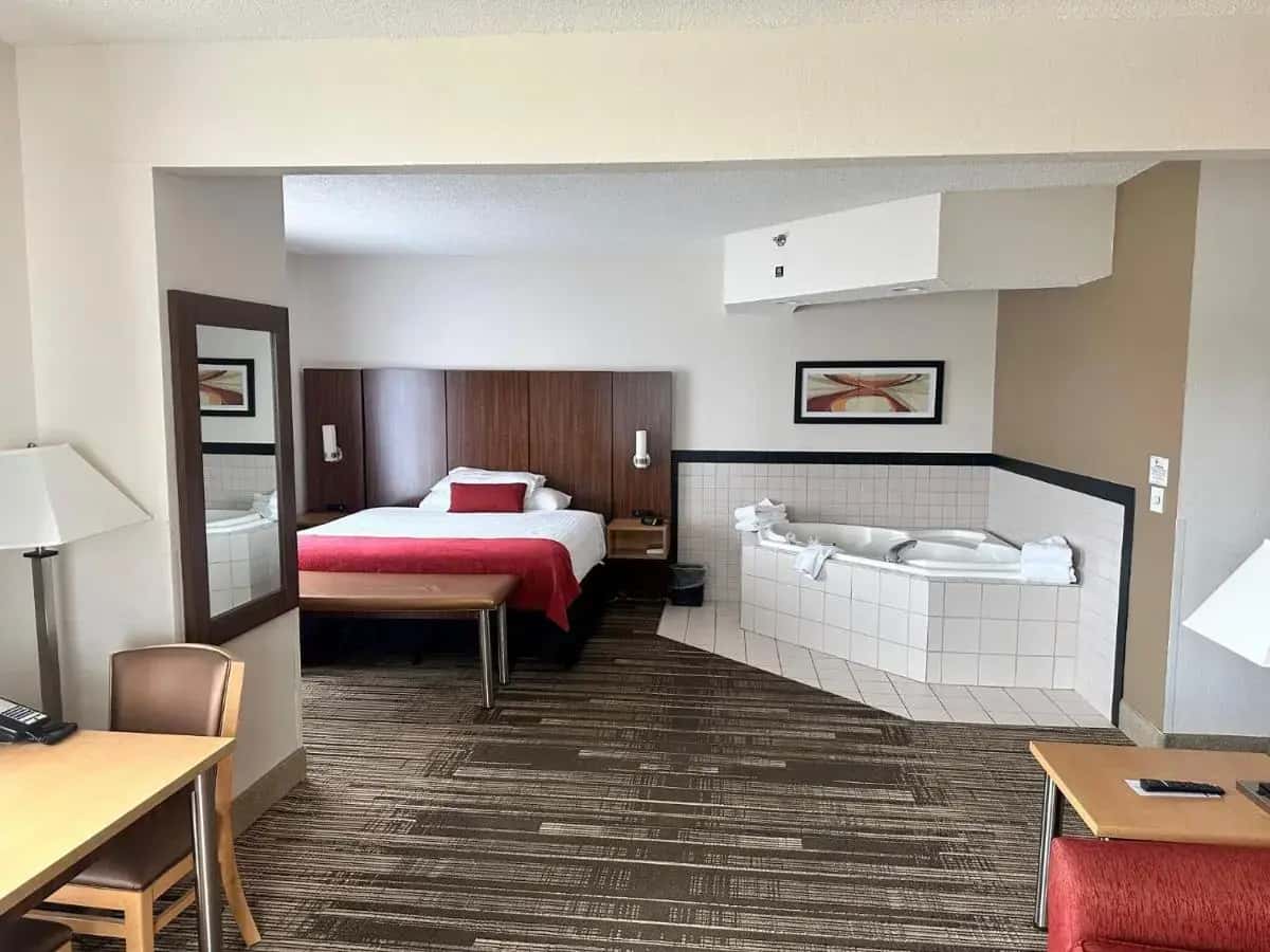 a hotel room with a bed and a table at Northfield Inn Suites and Conference Center in Springfield