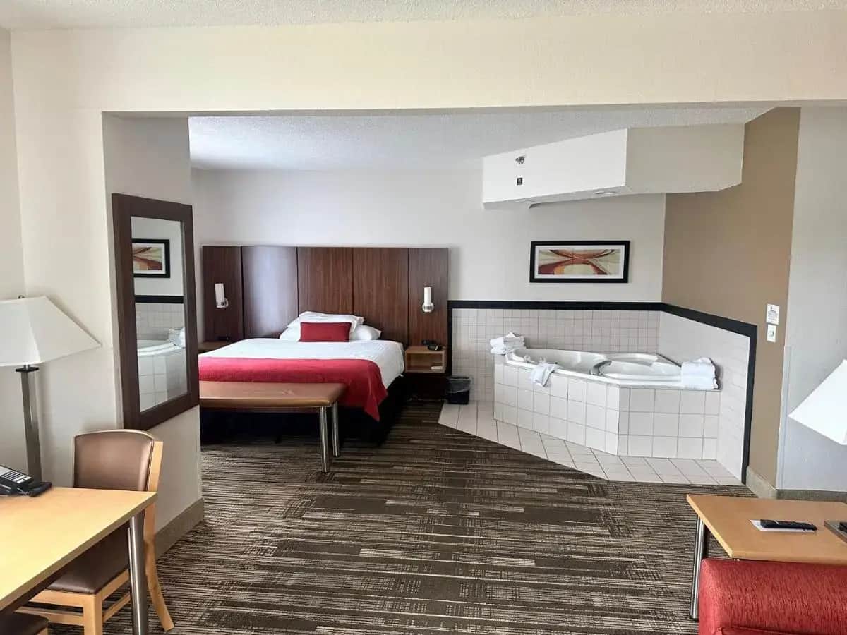 a hotel room with a bed and a table at Northfield Inn Suites and Conference Center in Springfield