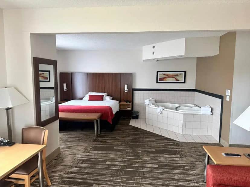 a hotel room with a bed and a table at Northfield Inn Suites and Conference Center in Springfield