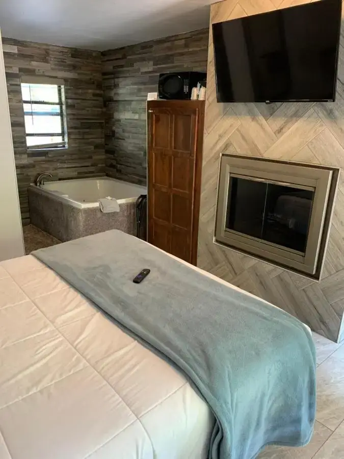 a bedroom with a bed and a tub and a television at Oak Creek Terrace Resort in Sedona