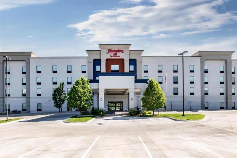 a white building with a red cross on the front at Hampton Inn Omaha/West Dodge Road, Old Mill in Boys Town