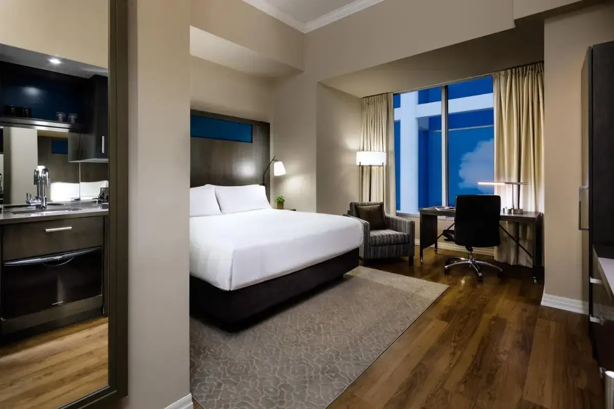 a hotel room with a bed and a desk and a kitchen at One King West Hotel and Residence in Toronto