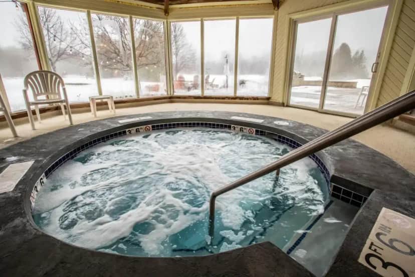 a jacuzzi tub in a house with snow at Open Hearth Lodge in Sister Bay
