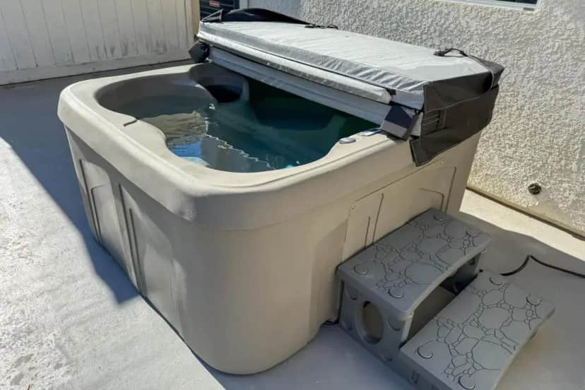 a bath tub sitting on the side of a building at Outdoor Oasis + Hot Tub! Spacious Clovis Home in Clovis