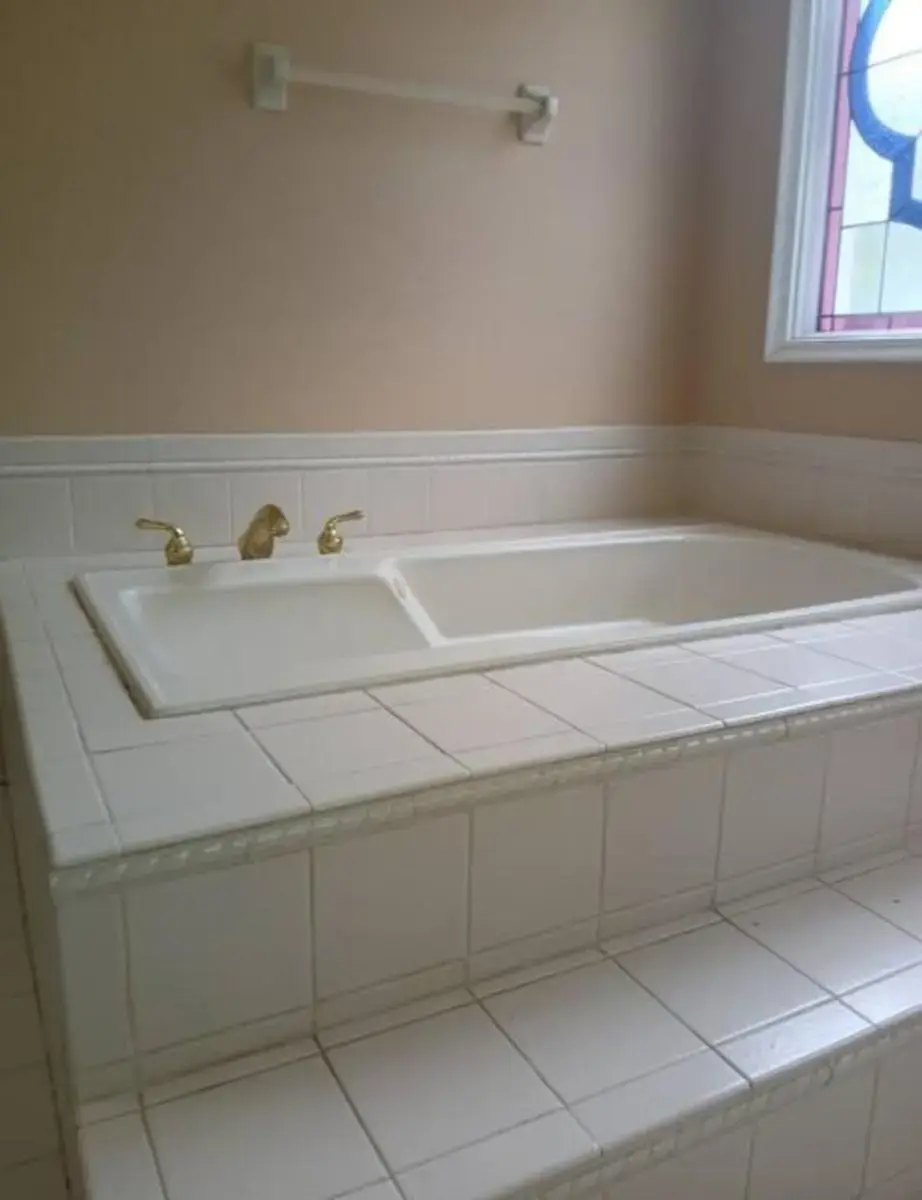 a white bath tub with a sink in a bathroom at Outer Access Room in Family Home in Loganville